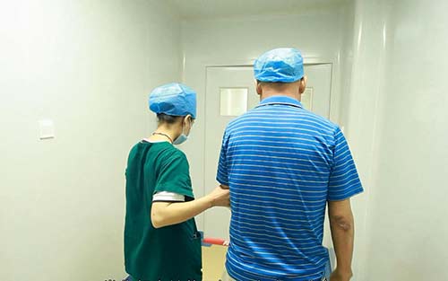 詹先生在医护人员的陪同下前往治疗室.jpg